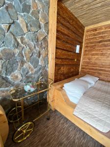 a room with a bed and a stone wall at Guest house Shulc in Mizhhirya