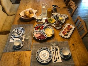 einem Holztisch mit Teller und Schüsseln aus Essen in der Unterkunft Landlust Ischl in Bad Ischl