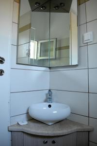 W łazience znajduje się umywalka i lustro. w obiekcie Vassilis Studio's w mieście Perivólion