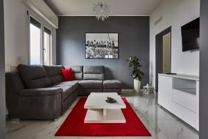 salon z kanapą i czerwonym dywanem w obiekcie House Paradise w mieście Perledo
