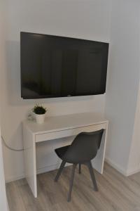 einem schwarzen Stuhl vor einem weißen Schreibtisch mit einem TV in der Unterkunft Sophie Superior Apartment in Karlsruhe