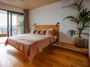 a bedroom with a bed and a potted plant at Tavarneta Estate in Dobrovo