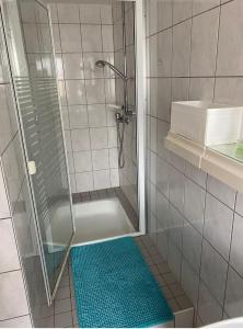 a bathroom with a shower and a blue rug at Olgas Ferienwohnung Saarburg Bahnhofstraße 13G in Saarburg