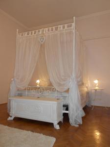 1 cama blanca con dosel en una habitación en Panorama, en Budapest