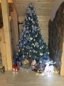 a christmas tree with presents under it in a room at Guest house Shulc in Mizhhirya