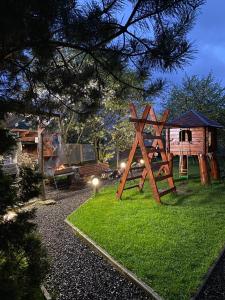 um parque infantil num quintal com uma estrutura de madeira em Guest house Shulc em Mizhhirya
