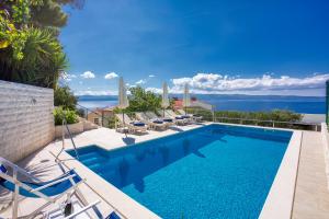 a swimming pool with chairs and a view of the ocean at Villa Zorka in Omiš