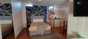 a small bedroom with a bed and a kitchen at Blacky Hostel and Apartments in Cusco