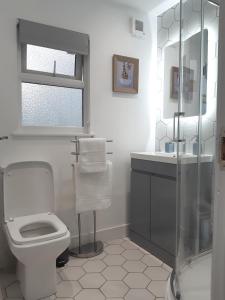 a white bathroom with a toilet and a sink at Chalet 174 Glan Gwna Park Caernarfon in Caeathro