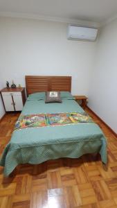 1 cama con edredón verde en un dormitorio en Chacara Ceara, en Monte Alegre do Sul