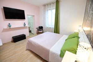a bedroom with a bed and a flat screen tv at La casa di Odessa in Arcevia