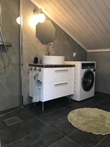 a bathroom with a sink and a washing machine at Fagerbacka Svit. Trivsam lägenhet nära havet in Lysekil +13 photos