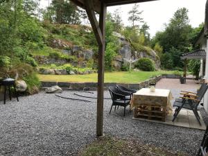 a patio with a table and chairs and a garden at Fagerbacka Svit. Trivsam lägenhet nära havet in Lysekil