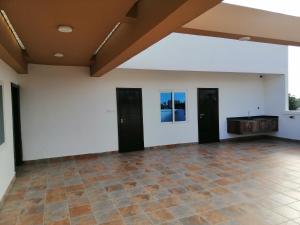 una stanza vuota con tre porte e un pavimento piastrellato di IMOLEASE HUBERT Sainte Rita a Cotonou