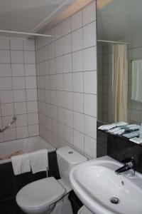 łazienka z umywalką, toaletą i wanną w obiekcie Hotel New Flanders w mieście Sint-Niklaas