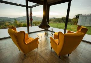 2 sillas y una mesa en una habitación con ventanas en Tavarneta Estate en Dobrovo