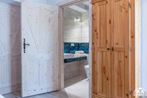 a bathroom with a wooden door and a toilet at Agroturystyka Corno Owca in Żabnica