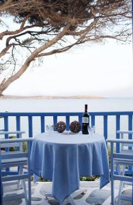 una mesa con una botella de vino y dos copas en Nissiotiko Hotel, en Drios