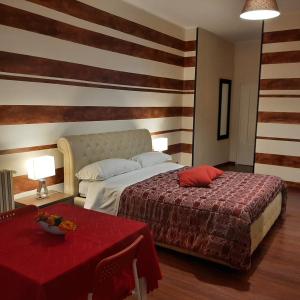 バーリにあるDolci Ricordiのベッドと赤いテーブルが備わるホテルルームです。