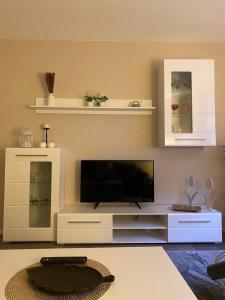 a living room with a tv and a white entertainment center at ferienwohnungen.ruhla in Ruhla