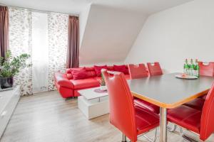 ein Wohnzimmer mit einem roten Sofa und einem Tisch in der Unterkunft Gutmensch Oberhausen 4 Schlafzimmer in Oberhausen