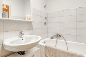 a white bathroom with a sink and a tub at Gutmensch Oberhausen 4 Schlafzimmer in Oberhausen +9 photos