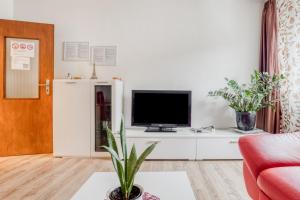 ein Wohnzimmer mit einem TV auf einem weißen Schrank in der Unterkunft Gutmensch Oberhausen 4 Schlafzimmer in Oberhausen