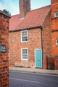 a brick building with a blue door on a street at Fourteen westgate in Louth