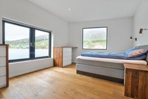 a bedroom with a bed and two windows at Volda Floating Home in Kvaløya