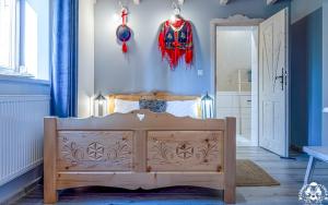 a bedroom with a wooden bed and a blue wall at Agroturystyka Corno Owca in Żabnica