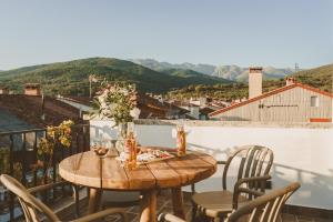 a table and chairs on a balcony with a view at La Corredera in Candeleda