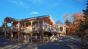 a large wooden house with a balcony on a hill at Mira Cottage in Marion Bridge