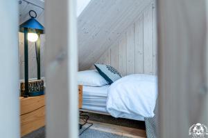 a bedroom with a bed with white sheets and pillows at Agroturystyka Corno Owca in Żabnica