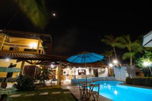 a resort with a swimming pool at night at Pousada Paraíso do Vento in Cumbuco