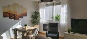 a living room with a table and chairs and a television at Miracle Morning in La Grande Motte