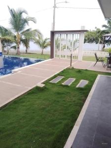 un patio con zona de césped junto a una piscina en Casa de Playa frente al mar. en Coveñas