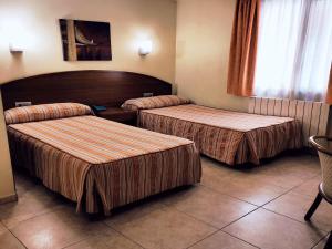 HOTEL FESTA BRAVA في أندورا لا فيلا: غرفة بسريرين في غرفة فندق