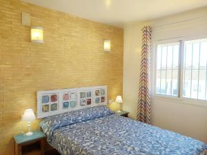 a bedroom with a bed and a brick wall at Gran adosado de esquina muy cerca de la playa en la Antilla in Huelva