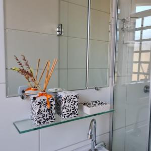 a glass shelf above a sink in a bathroom at Pousada Vitória da Vila in Brasília