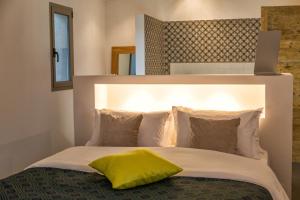 a bedroom with a bed with a yellow pillow on it at Hotel Les Chambres de Mila Bonifacio in Bonifacio