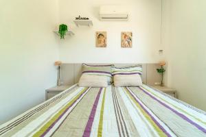 1 dormitorio con 1 cama con colcha a rayas de colores en Refúgio dos Pássaros - Bombinhas - Casa Da Ca, en Bombinhas