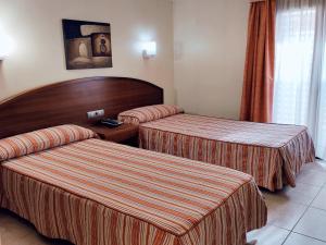 a hotel room with two beds and two nightstands at HOTEL FESTA BRAVA in Andorra la Vella