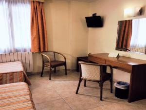 安道爾城的住宿－HOTEL FESTA BRAVA，客房设有书桌、两把椅子和一张桌子