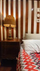 a lamp on a night stand next to a bed at locanda cecchini in Campos do Jordão