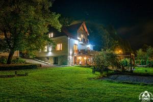 a house lit up at night with lights at Agroturystyka Corno Owca in Żabnica
