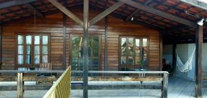 Cabaña con paredes y ventanas de madera y porche en Família Capetti, en Bauru