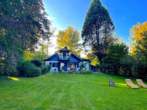 ein blaues Haus mitten im Garten in der Unterkunft See-Chalet Riederau in Dießen am Ammersee