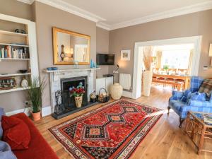 a living room with a fireplace and a blue couch at Victoria Lodge in Kingsbridge