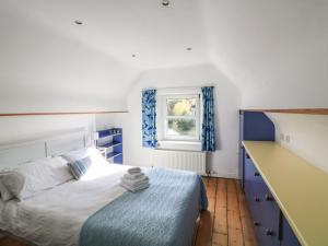 Un dormitorio con una cama azul y blanca y una ventana. en Victoria Lodge, en Kingsbridge