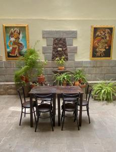a wooden table and chairs in a room with plants at Hostal Casona Arrambide in Cusco